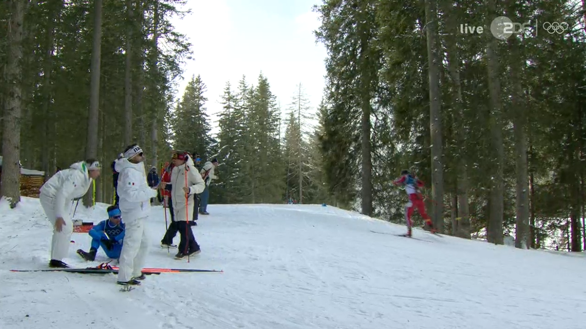 Tommaso Giacomel sitzt im Schnee, Betreuer sind bei ihm.
