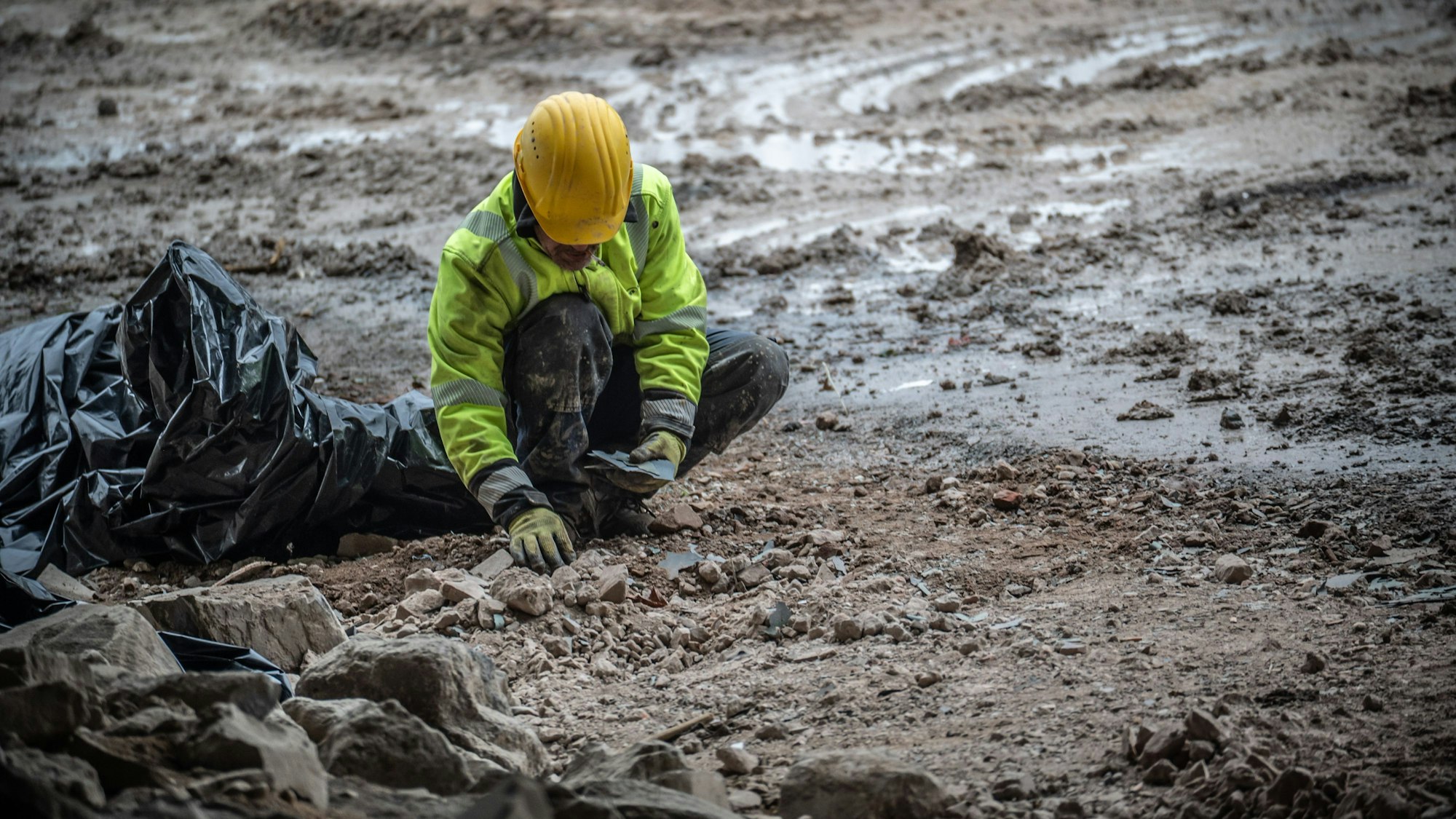 Arbeiter sammeln Kunststoffteilchen ein.