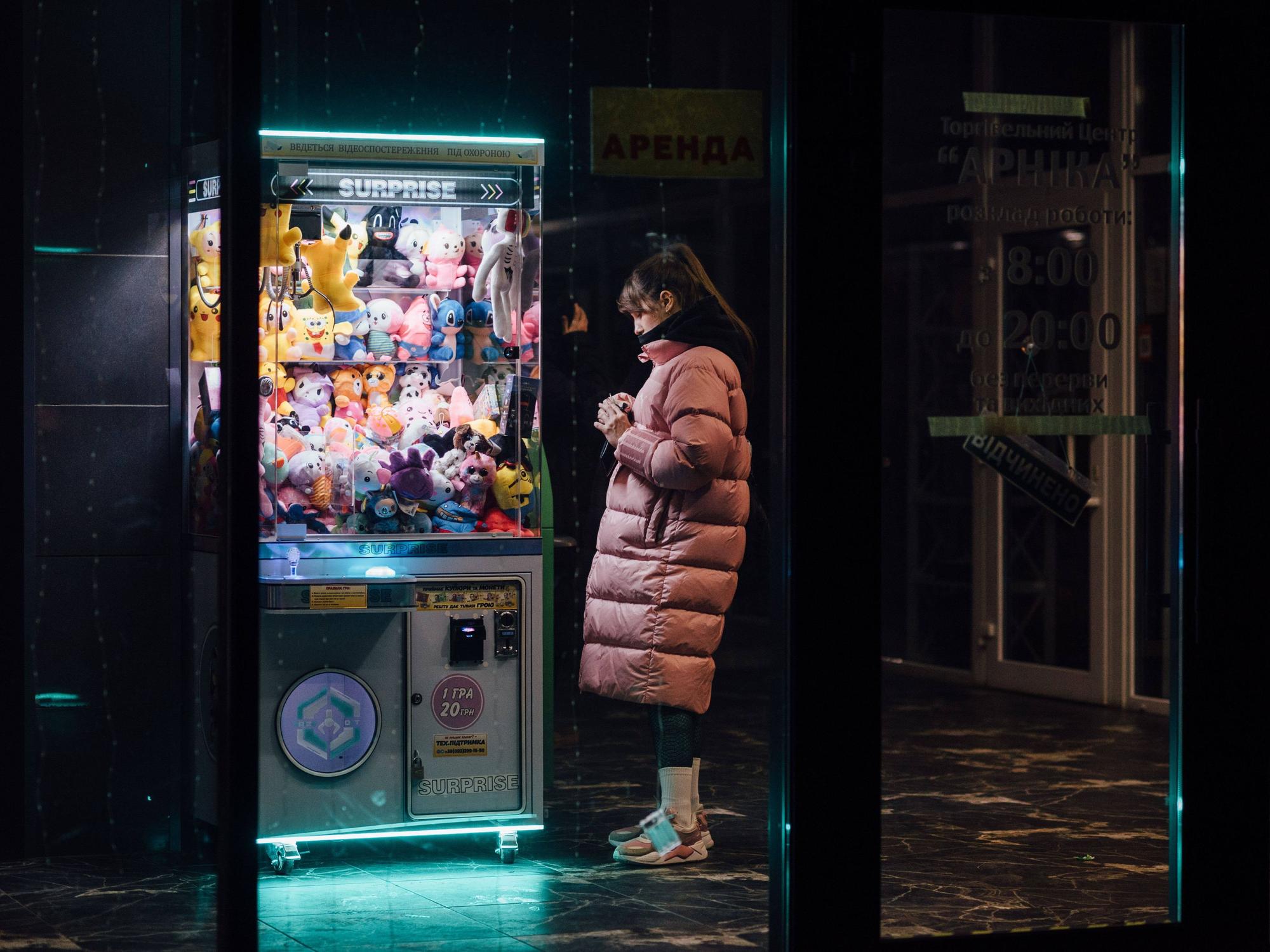 Ein Mädchen steht Ende Dezember neben einem Spielzeugautomaten, der während eines Stromausfalls in Dnipro mit Notstrom betrieben wird. Supermärkte, Geschäfte und andere öffentliche Einrichtungen in der ganzen Stadt sind aufgrund der Stromausfälle auf Generatoren angewiesen.