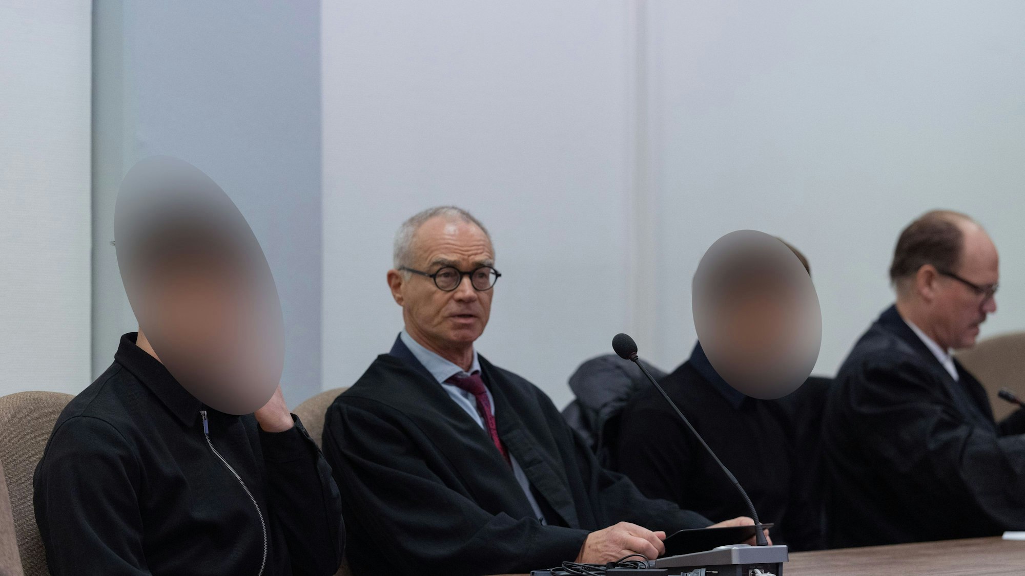 Die beiden Angeklagten sitzen im Landgericht Köln neben ihren Anwälten.