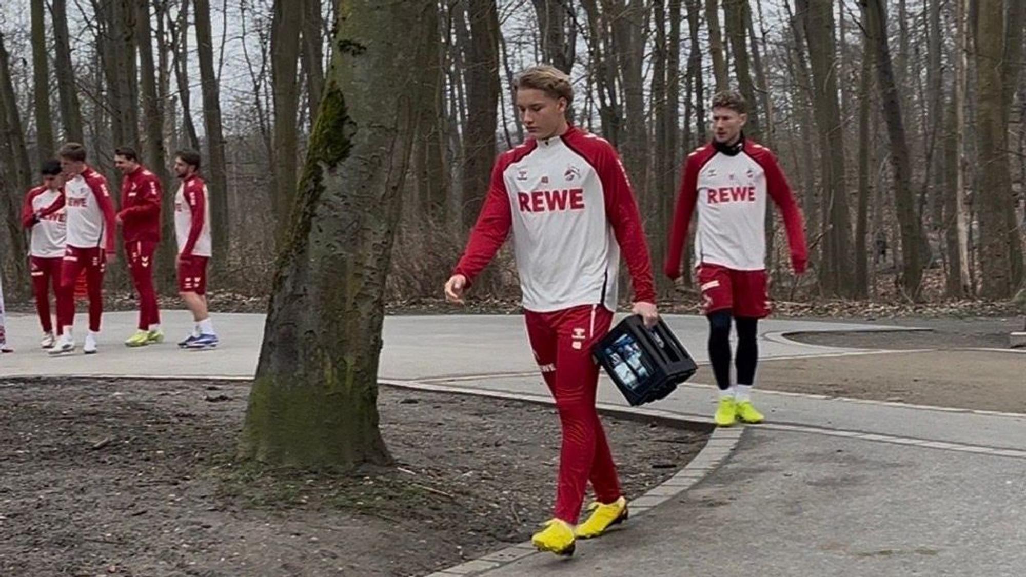 Fynn Schenten kommt mit einem Wasserkasten zum Abschlusstraining.