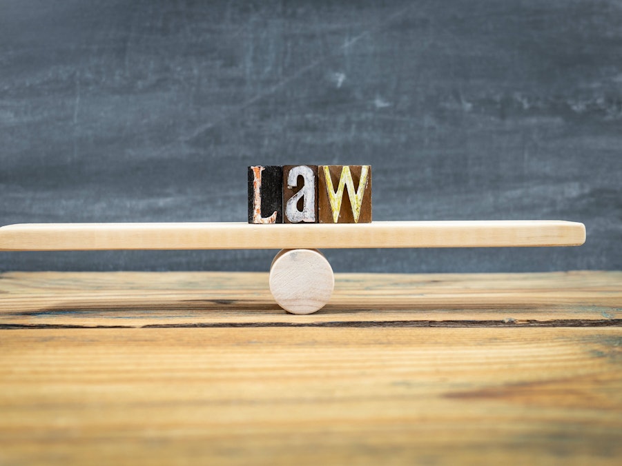 „LAW“ Holzklötze auf balancierender Wippe