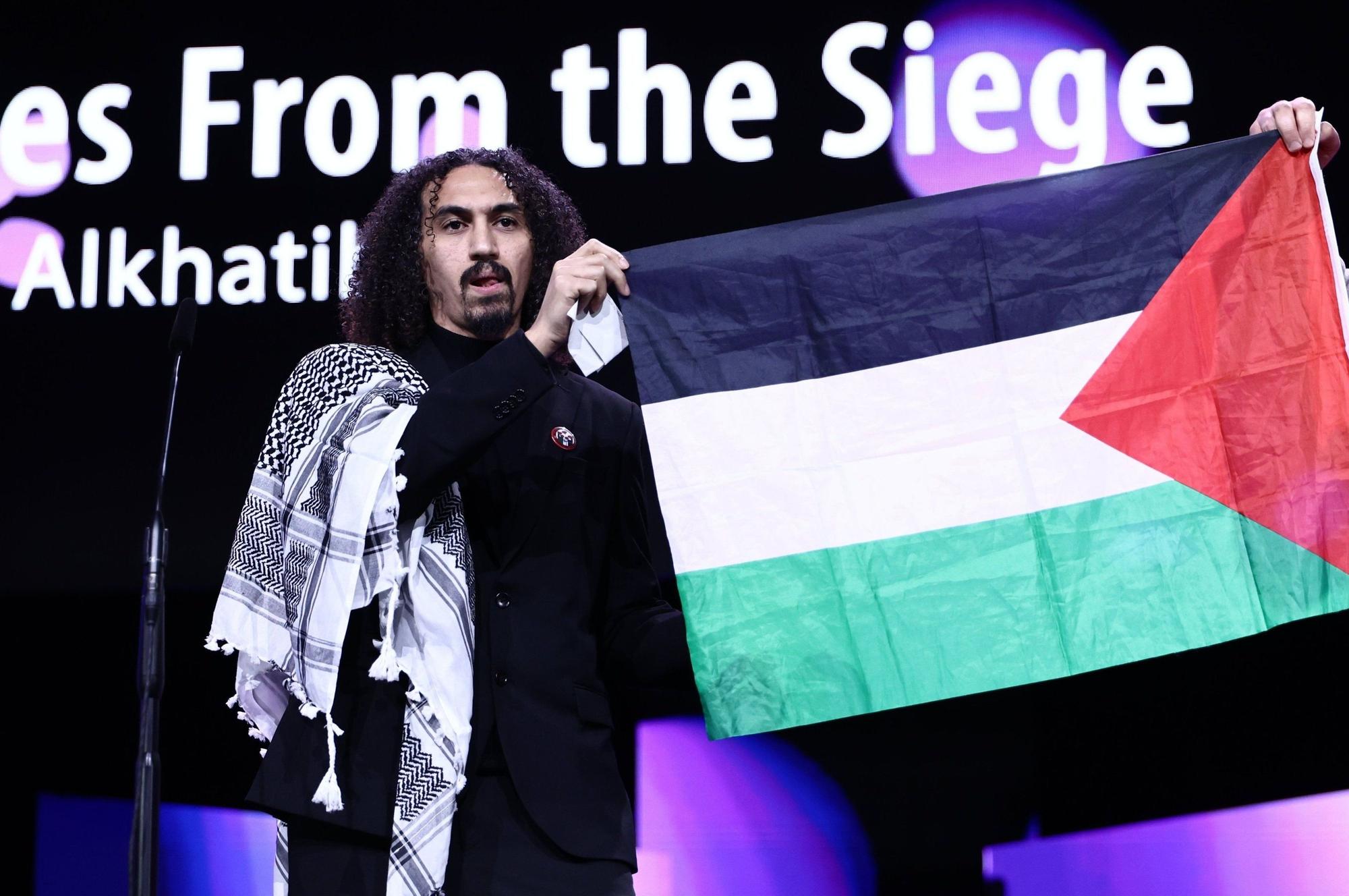 Regisseur Abdallah Alkhatib hält eine palästinensische Fahne hoch.