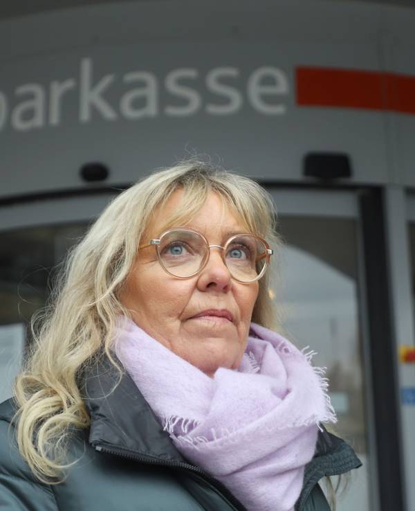 20.02.2026, Nordrhein-Westfalen, Gelsenkirchen: Die durch den spektakulären Millionen-Einbruch in eine Sparkasse geschädigte Kundin Astrid Kaiser steht vor der betroffenen Filiale.