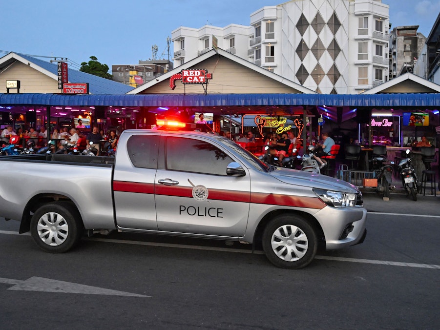Ein Polizeiwagen mit Warnlicht fährt eine Staße entlang.