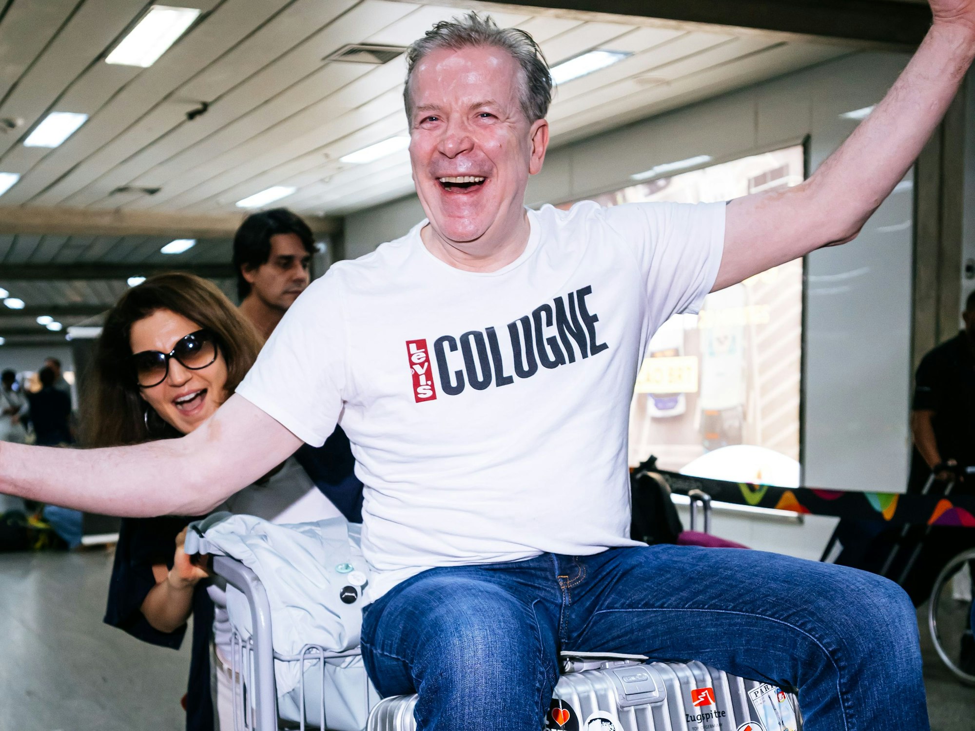 Christoph Kuckelkorn lässt sich von Ehefrau Katia durch den Flughafen schieben.