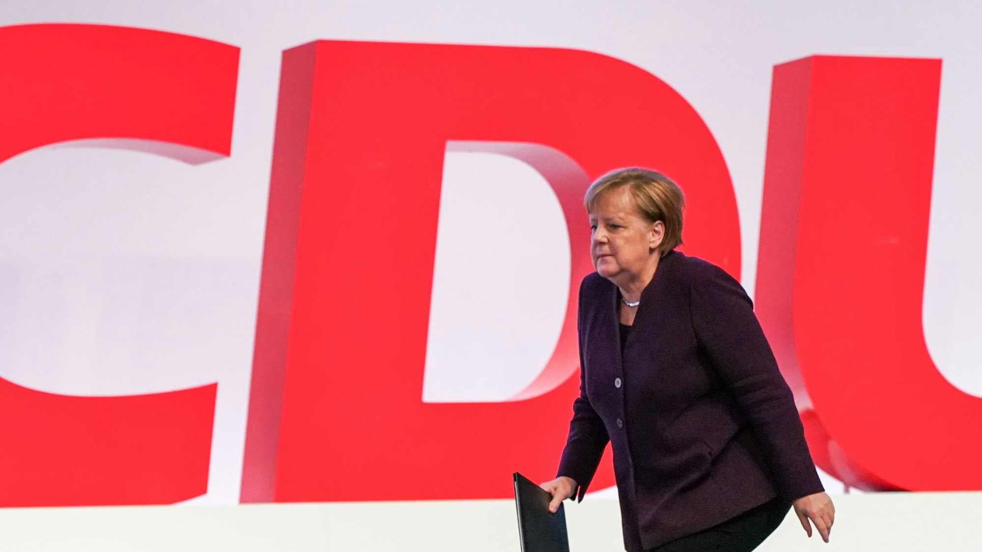 Ex-Bundeskanzlerin Angela Merkel (CDU) läuft an riesigen Buchstaben CDU vorbei.