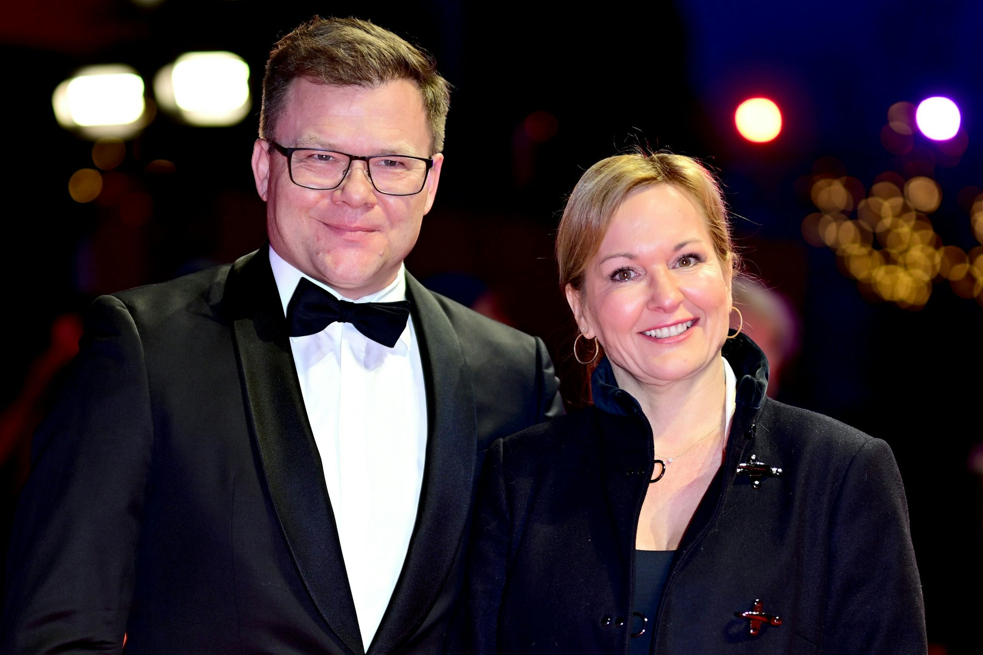 Carsten Schneider (l, SPD), Bundesminister für Umwelt, Klimaschutz, Naturschutz und nukleare Sicherheit, und seine Begleitung stehen bei der Ankunft zur Preisverleihung der Berlinale auf dem Roten Teppich vor dem Berlinale Palast.