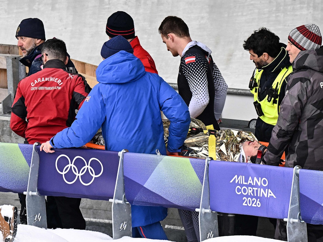 Helfer und seine Anschieber bringen Jakob Mandlbauer auf einer Trage von der Bahn.