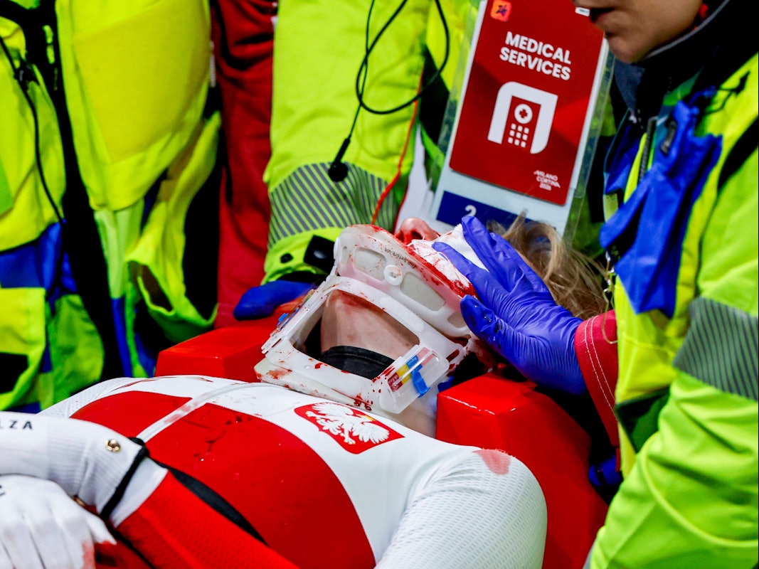 Kamila Sellier wird mit einer Trage vom Eis gebracht. Jemand hält einen Verband auf ihre Wunden.