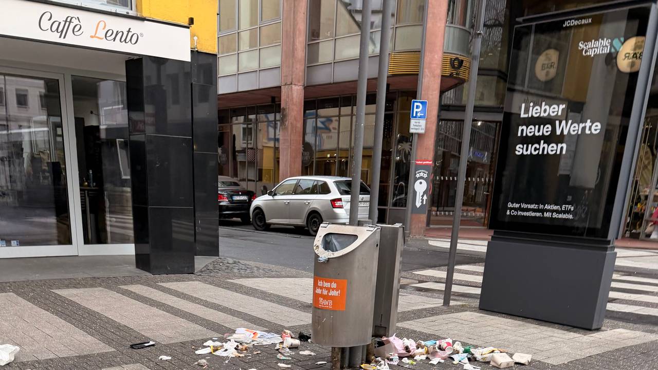 Auf der Breite Straße in Köln liegt am Morgen des 22. Februar 2026 Müll um Abfalleimer herum verteilt.