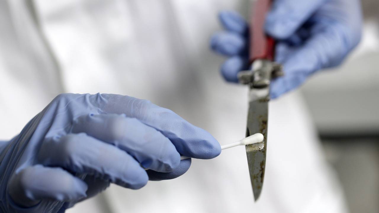 Eine Labormitarbeiterin streicht mit einem Q-Tip über die Klinge eines Messers.