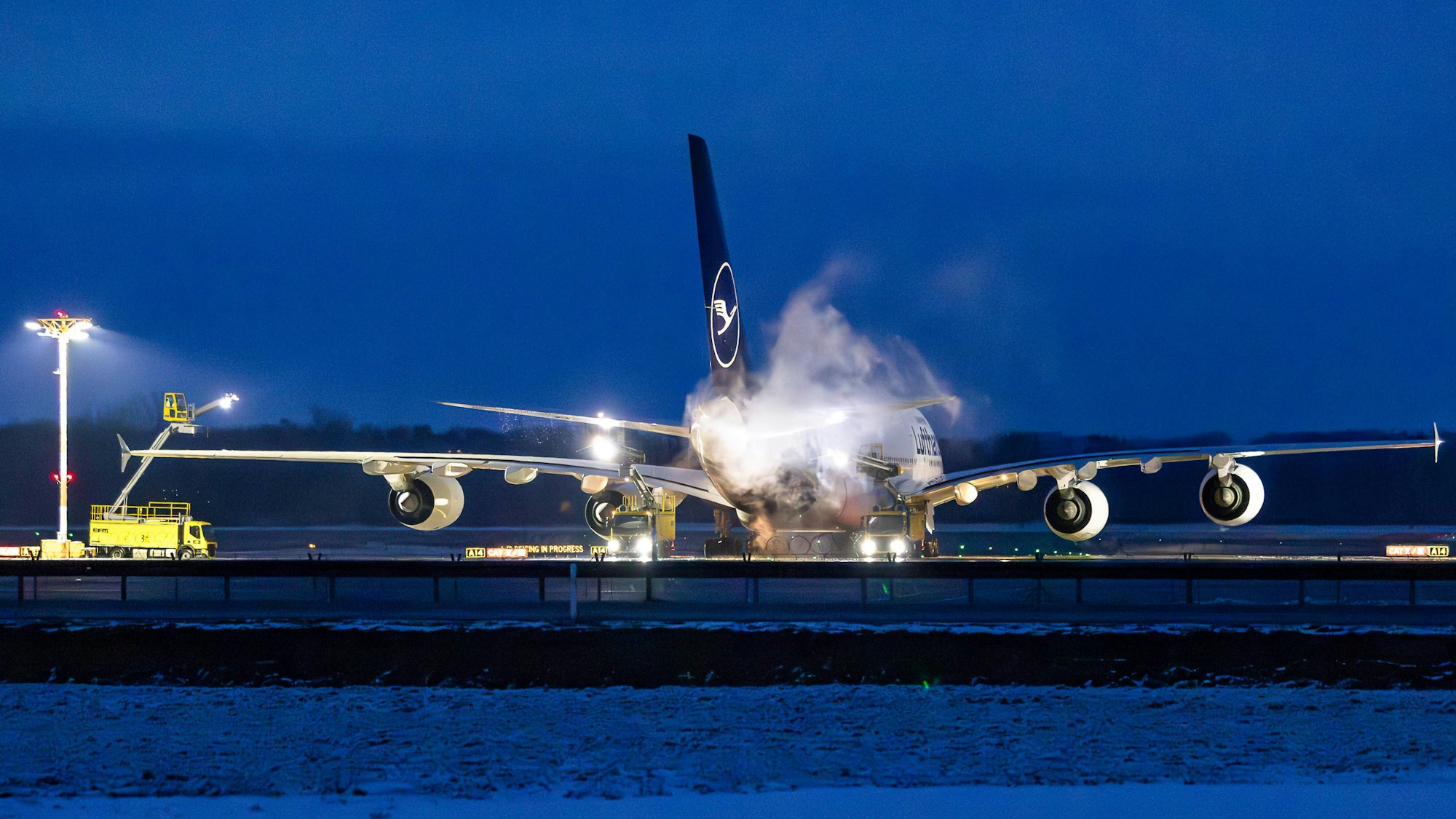 Flugzeug und Arbeitsfahrzeuge auf verschneitem Rollfeld