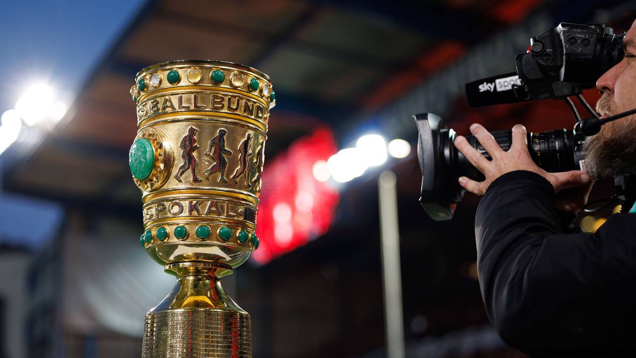 Der DFB-Pokal steht auf einem Sockel und wird von einem Kameramann gefilmt.