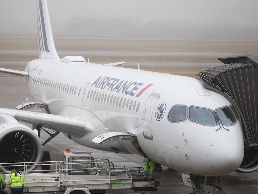 Flugzeug mit Fluggastbrücke und Bodenpersonal