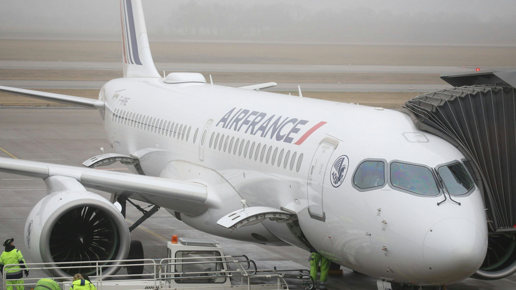 Flugzeug mit Fluggastbrücke und Bodenpersonal