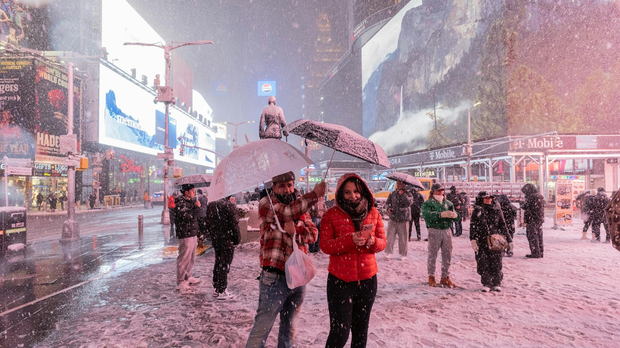 Menschen mit Schirmen in verschneiter Stadt