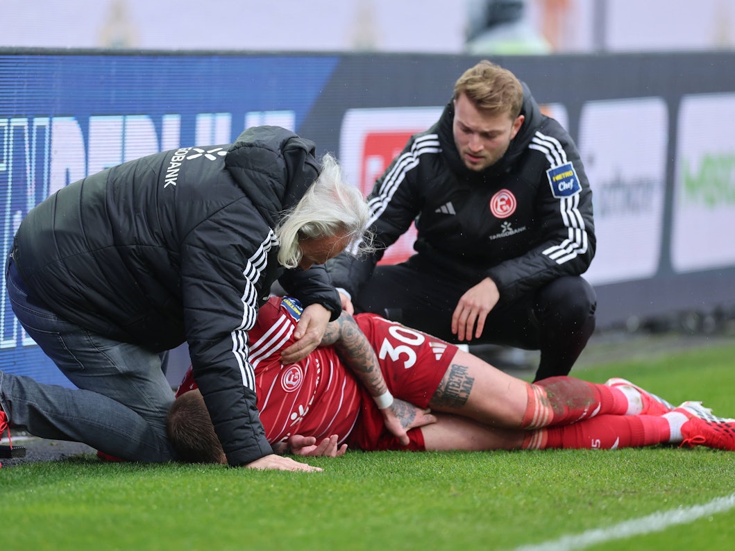 Jordy de Wijs wird von zwei Ärzten von Fortuna Düsseldorf am Seitenrand behandelt.