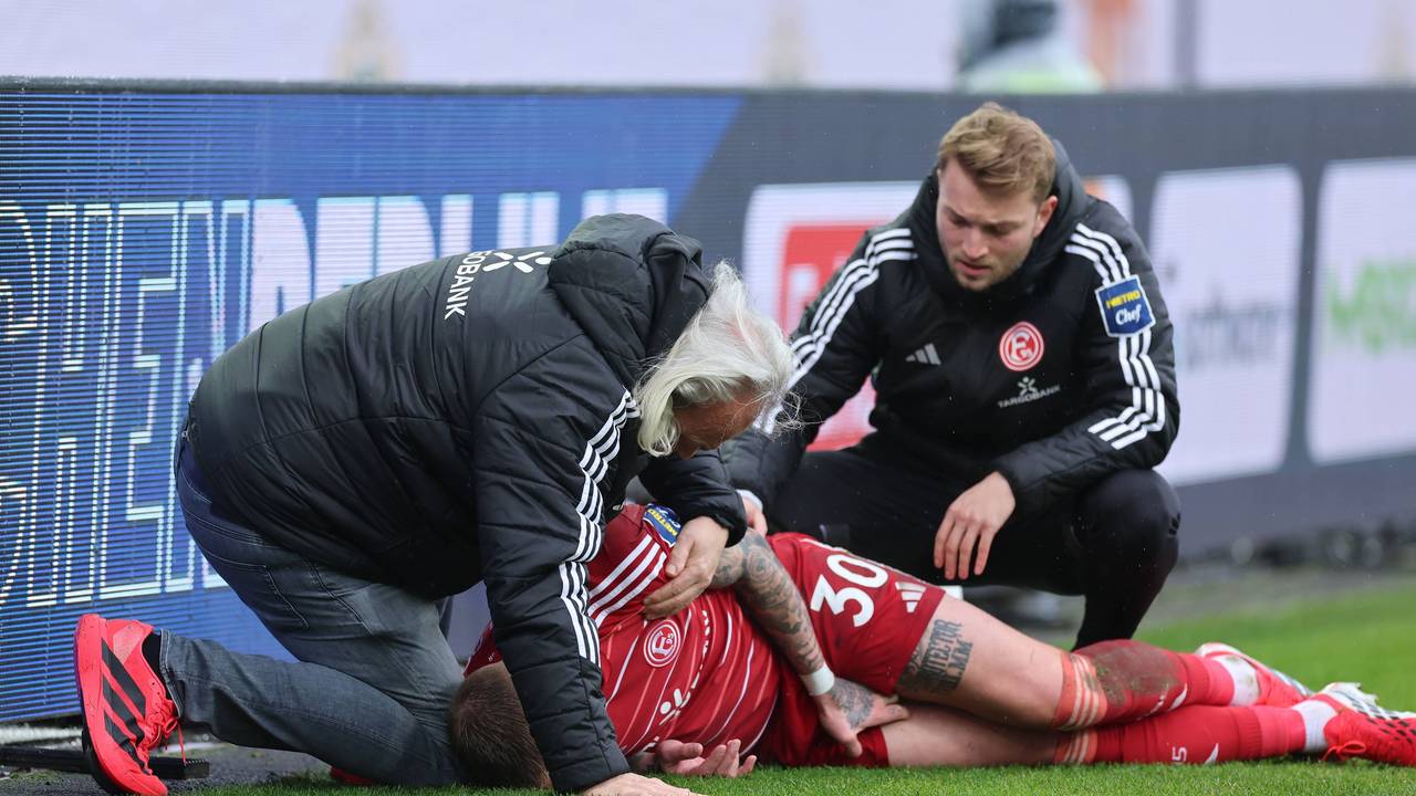 Jordy de Wijs wird von zwei Ärzten von Fortuna Düsseldorf am Seitenrand behandelt.