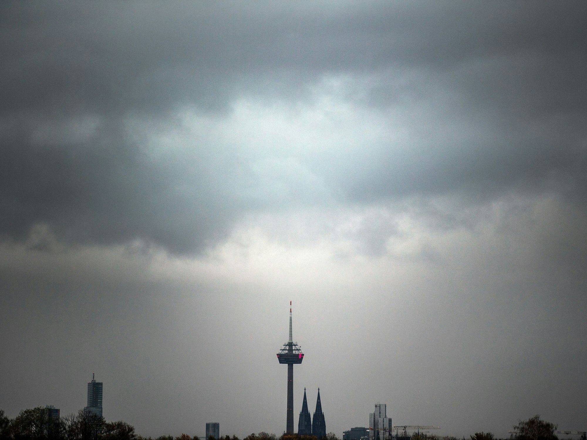 Wolken ziehen am Morgen über den Kölner Dom und den Fernsehturm.