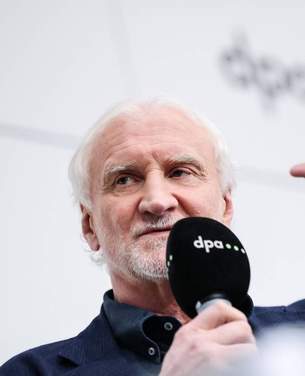 Rudi Völler spricht bei einer Veranstaltung ins Mikrofon.