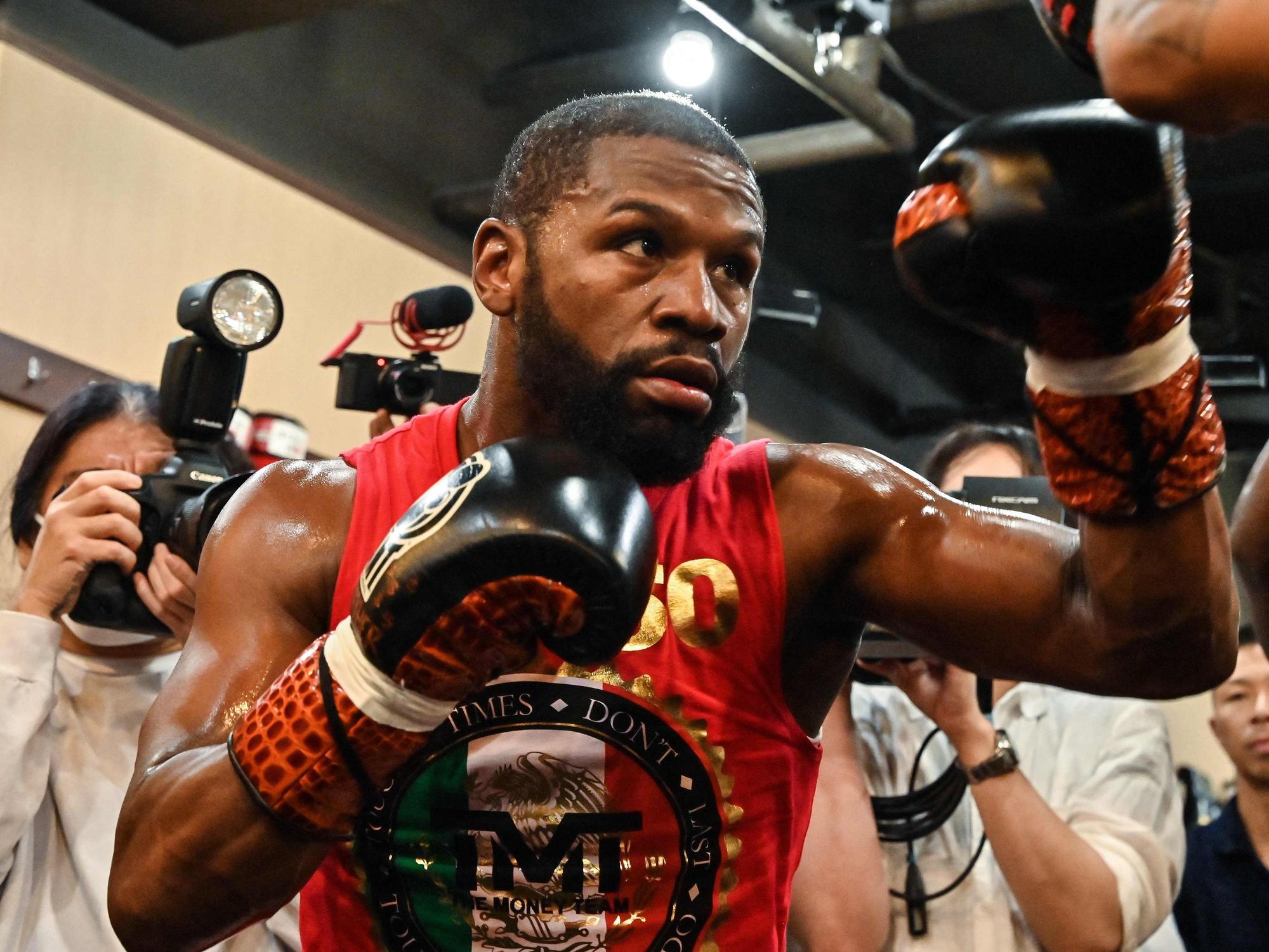 Box-Star Floyd Mayweather steht in Kampfpose mit Journalisten zusammen.
