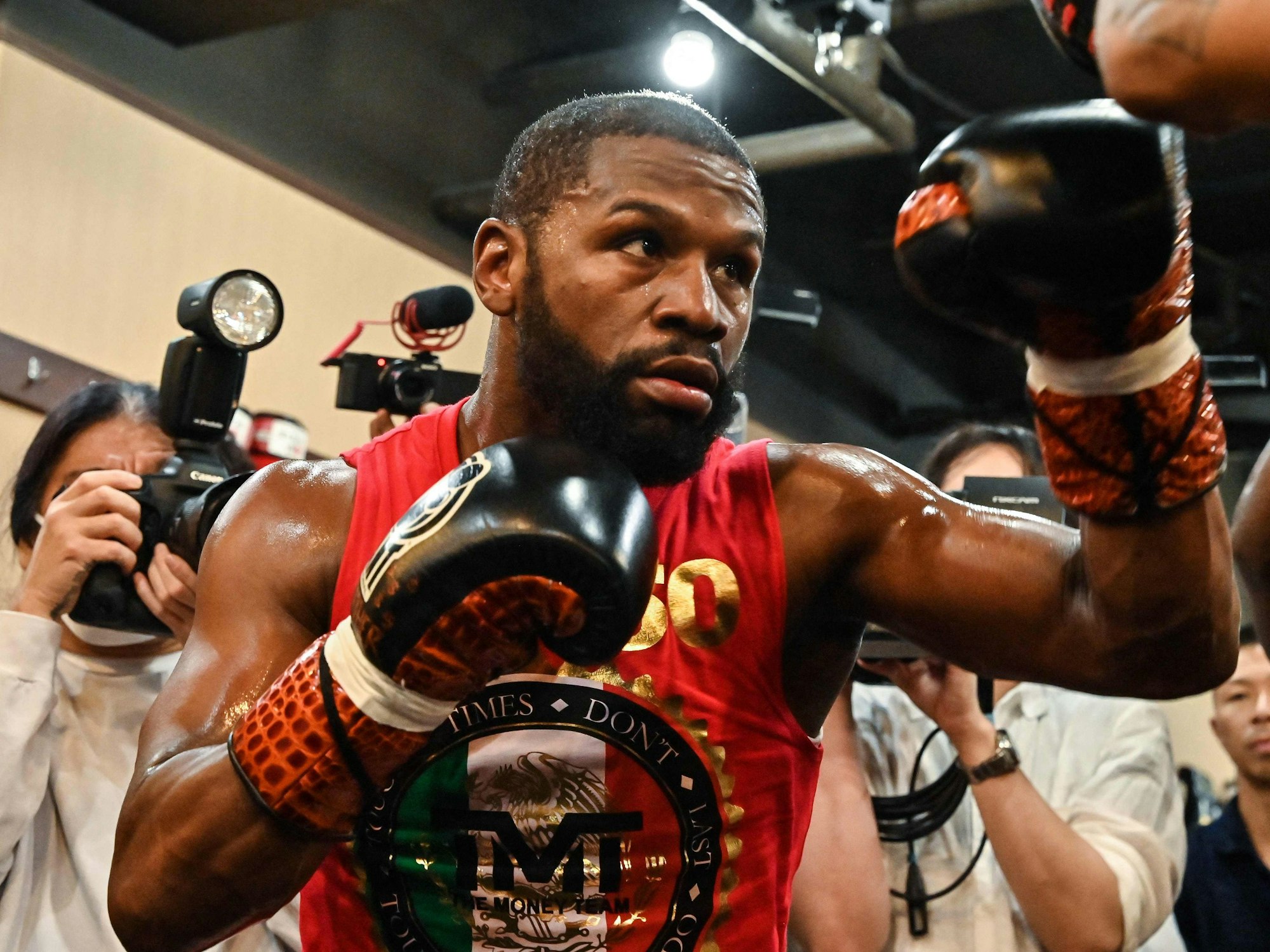 Box-Star Floyd Mayweather steht in Kampfpose mit Journalisten zusammen.