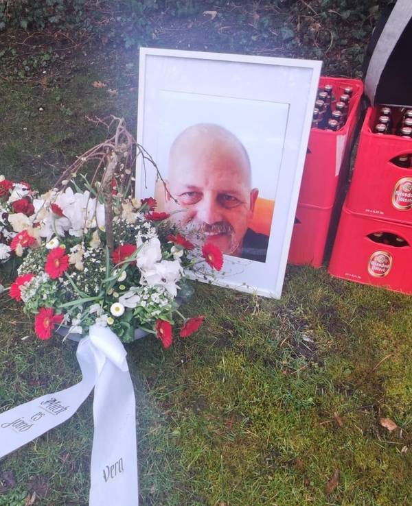 Das Foto eines Mannes lehnt an zwei gestapelten Kölsch-Kisten.