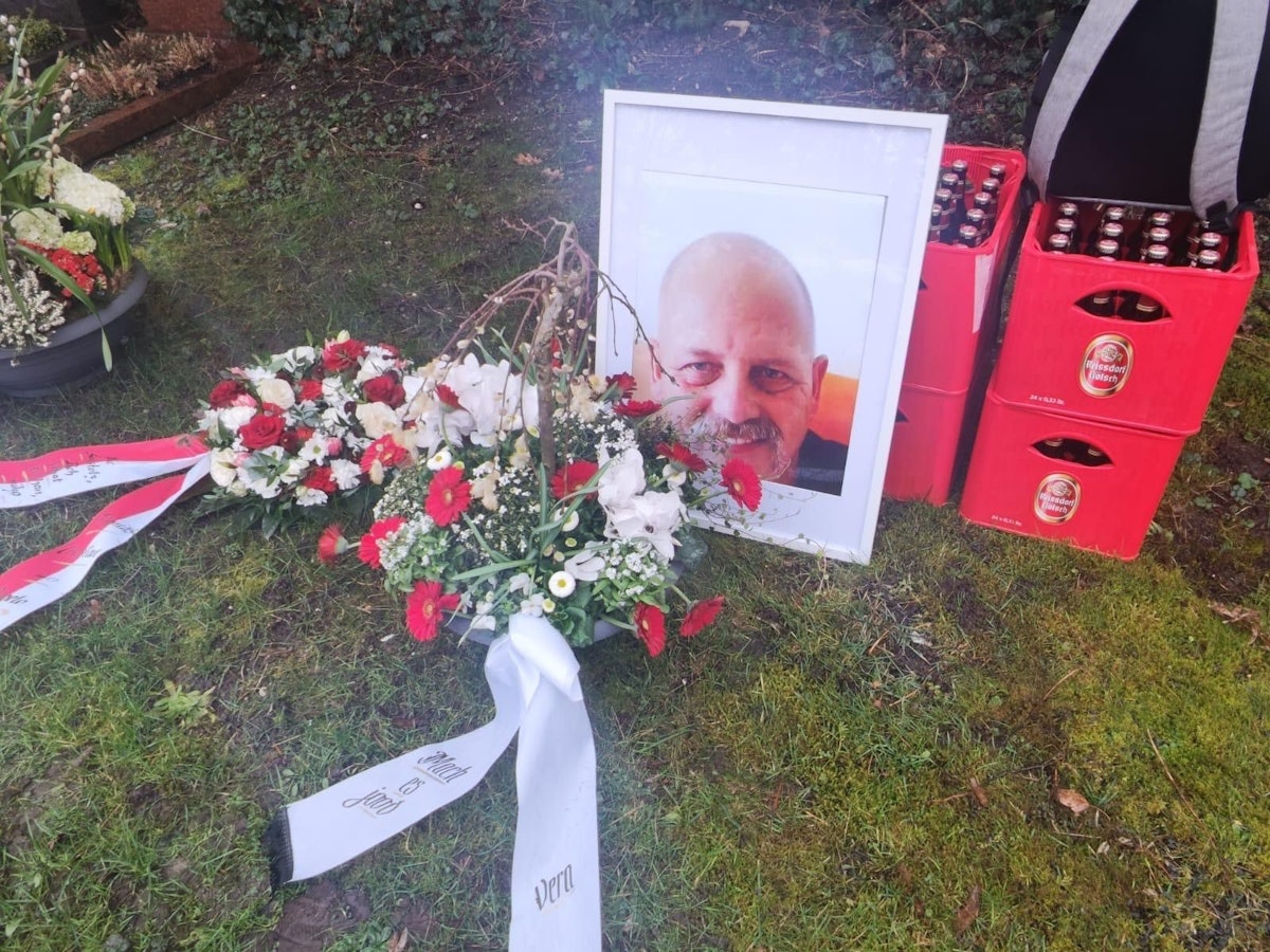 Das Foto eines Mannes lehnt an zwei gestapelten Kölsch-Kisten.