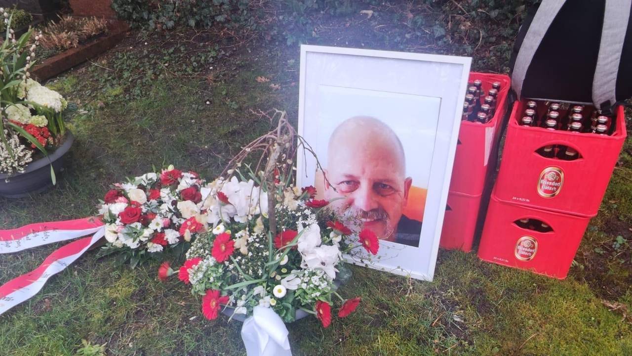 Das Foto eines Mannes lehnt an zwei gestapelten Kölsch-Kisten.