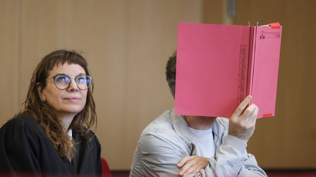Rechtsanwältin Hannah Milena Piel (l) sitzt neben ihrem Mandanten, der sich einen Aktenordner vor das Gesicht hält, im Prozess um die Ermordung eines Professors im Jahr 1984 in Hilden. Der „Cold Case“ konnte nach Jahrzehnten durch einen DNA-Treffer aufgeklärt werden. Angeklagt ist ein 62-Jähriger Mann, der aus Italien an die deutsche Justiz ausgeliefert wurde.