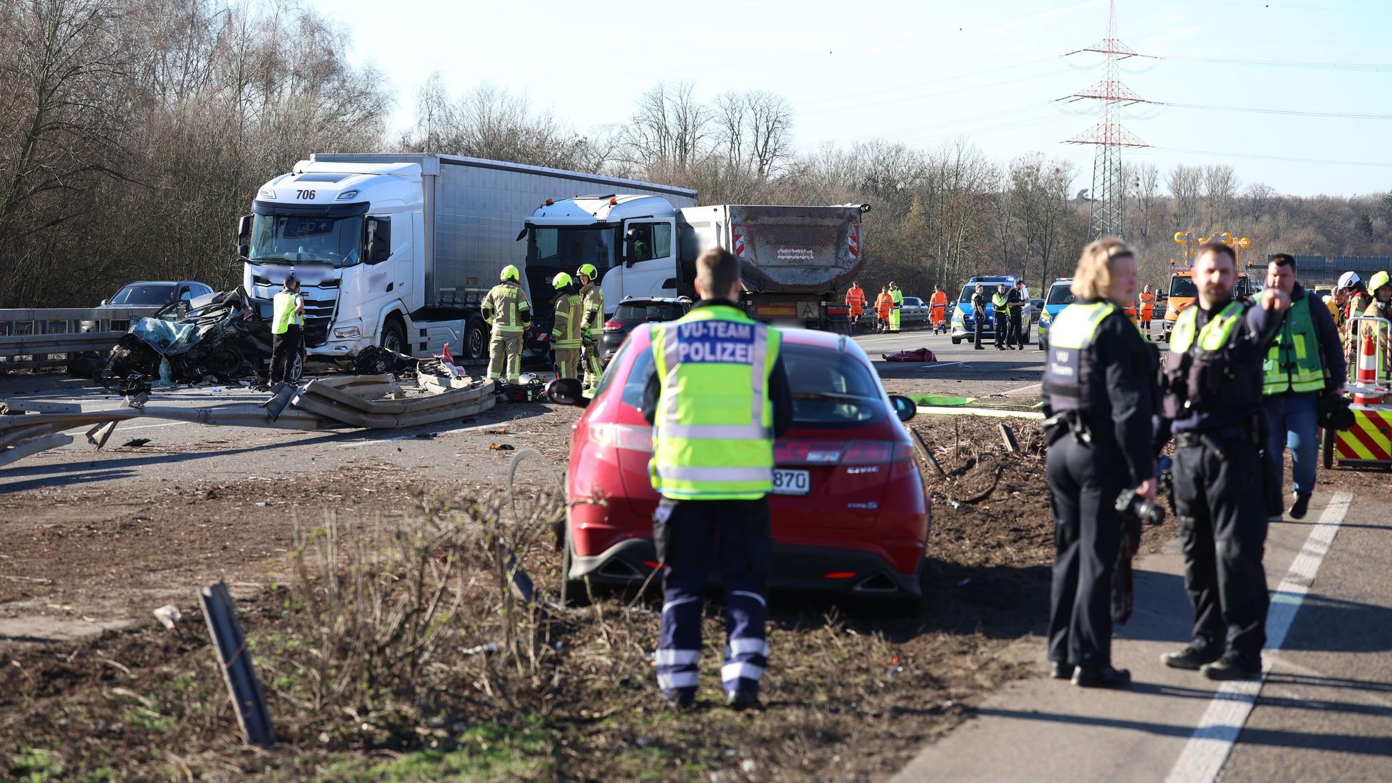 Einsatzkräfte stehen an einer Unfallstelle mit mehreren beschädigten Fahrzeugen.