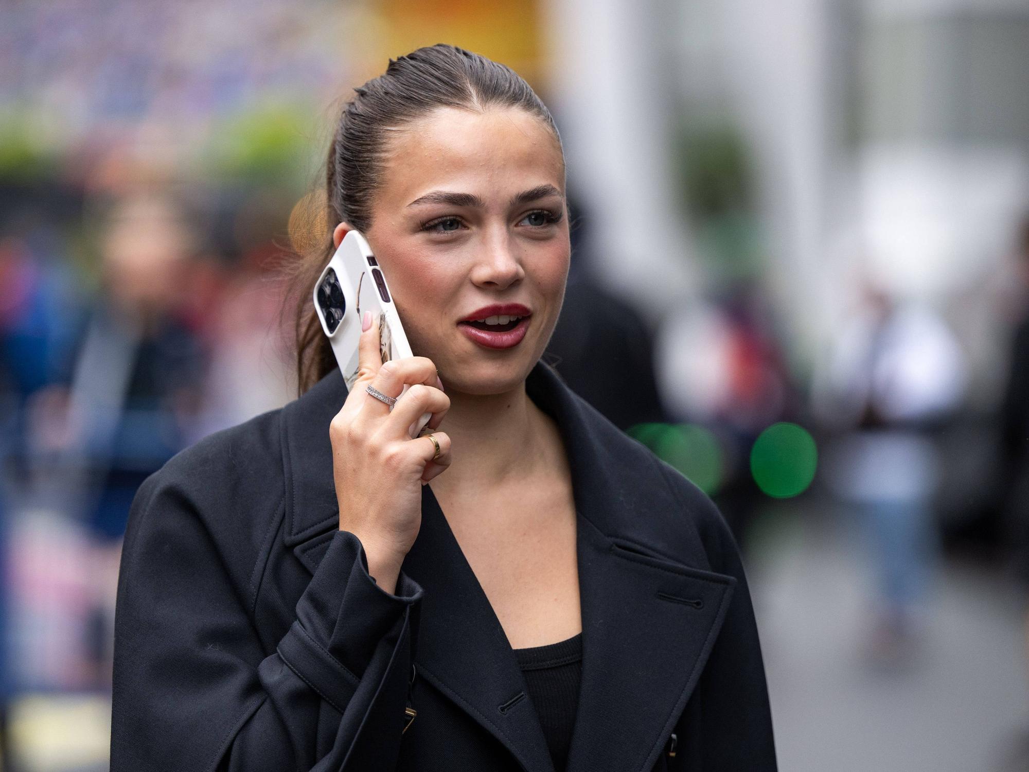 Eliska Babickova telefoniert am Rande eines Formel-1-Rennens.
