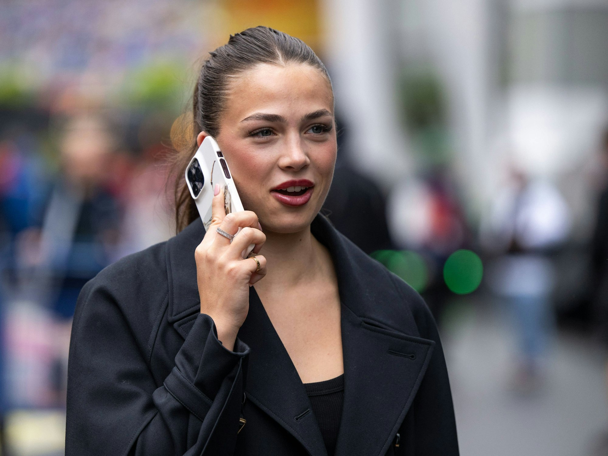 Eliska Babickova telefoniert am Rande eines Formel-1-Rennens.