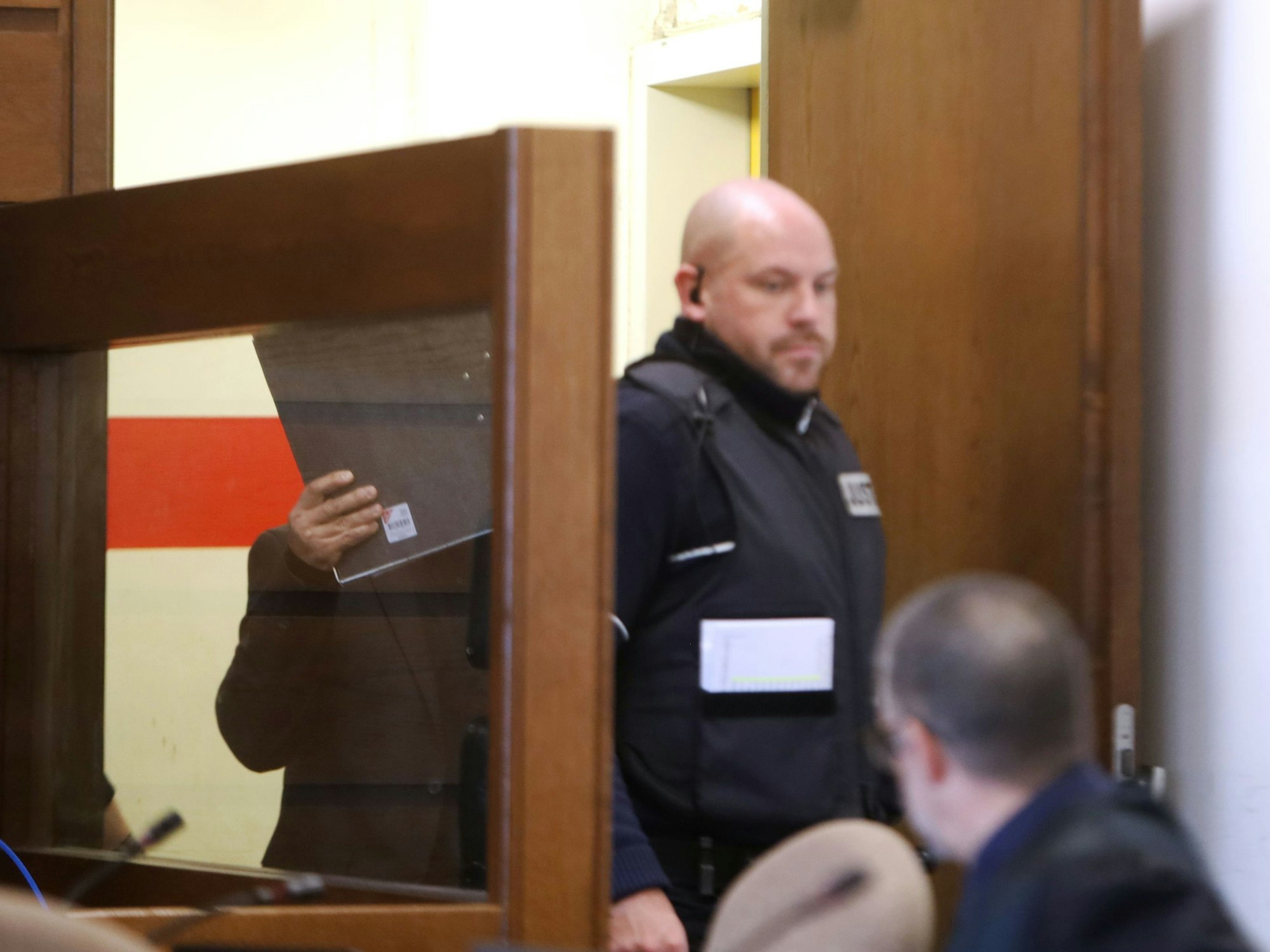 Ein Justizbeamter führt den Angeklagten in den Gerichtssaal in Köln.