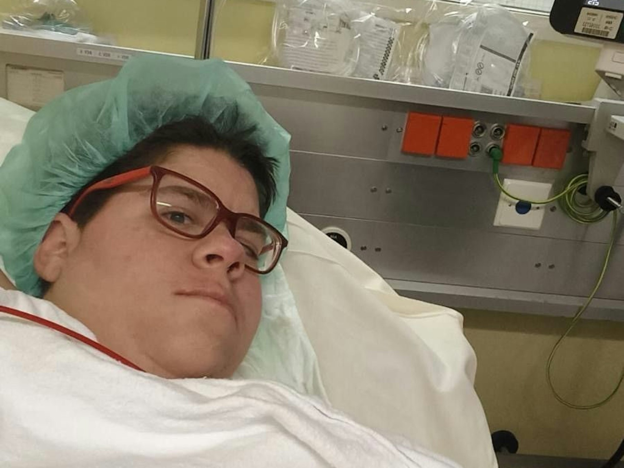 Maria liegt mit einer OP-Haube im Krankenhaus.