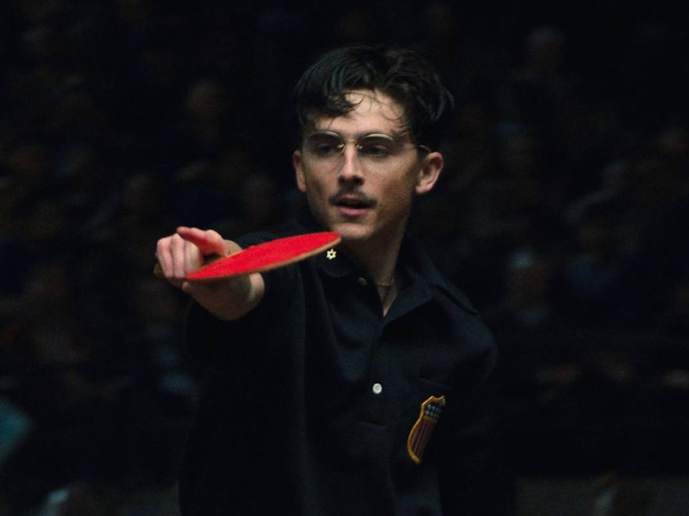 Timothée Chalamet zeigt in „Marty Supreme“ nicht nur, dass er gut schauspielern, sondern auch gut Tischtennis spielen kann. Besser als ein gewisser Schauspielkollege wird er den Schläger jedoch kaum geschwungen haben. Den der ist eine echte Legende des Sports - und stammt übrigens aus Deutschland. (Bild: Tobis Film)