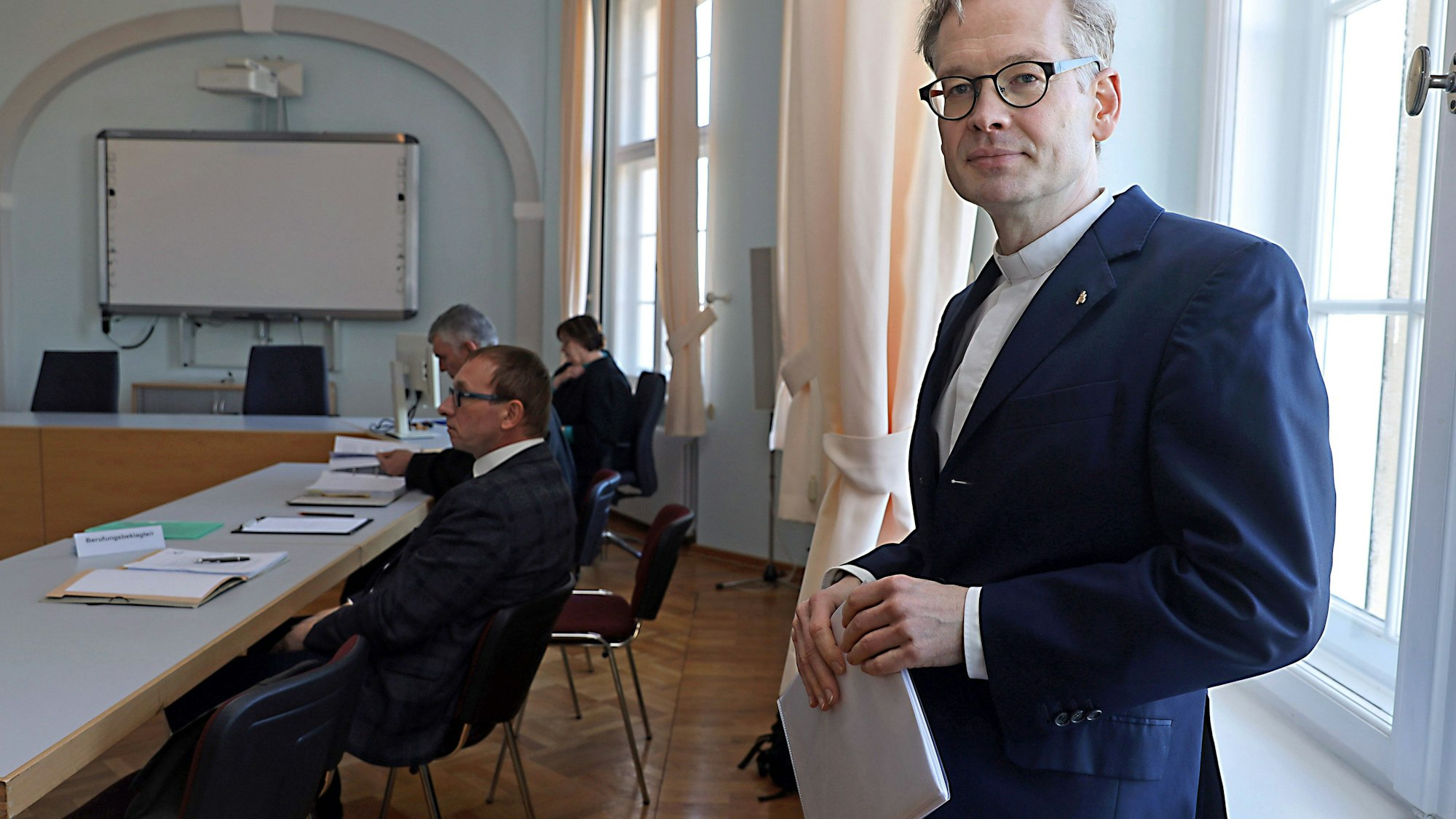 Johannes Block in Anzug und Konferenzraum