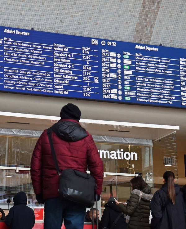 Ein Mann steht im Hauptbahnhof vor der Anzeigentafel mit den An- und Abfahrten.