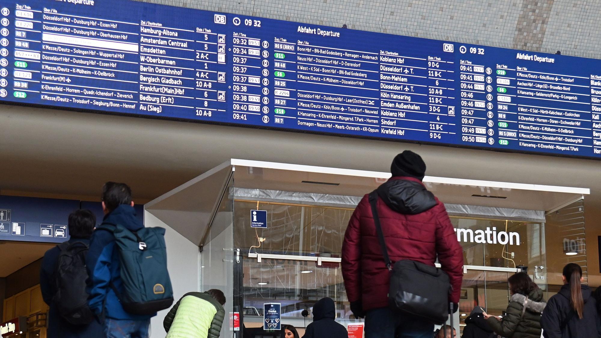 Ein Mann steht im Hauptbahnhof vor der Anzeigentafel mit den An- und Abfahrten.