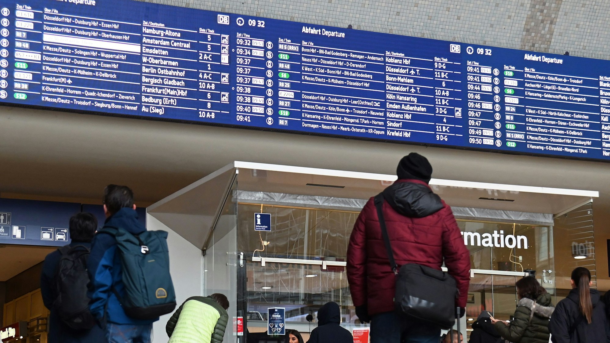 Ein Mann steht im Hauptbahnhof vor der Anzeigentafel mit den An- und Abfahrten.