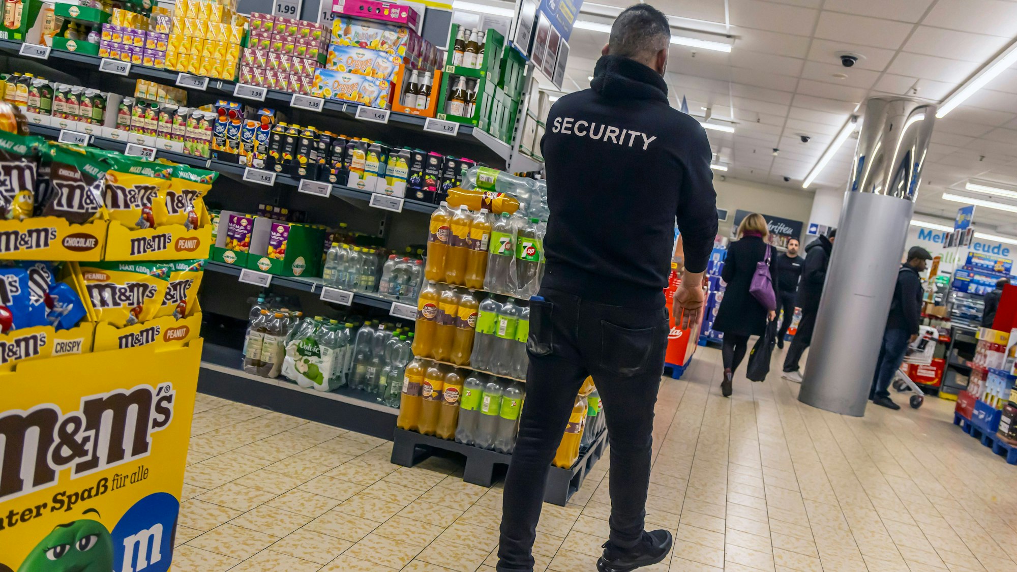 Sicherheitspersonal und Kunden in einem Supermarkt