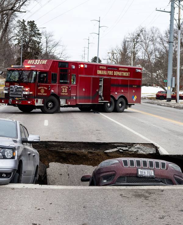 Zwei Fahrzeuge liegen auf der Pacific Street östlich der 67th Street in Omaha in einem Sinkloch.