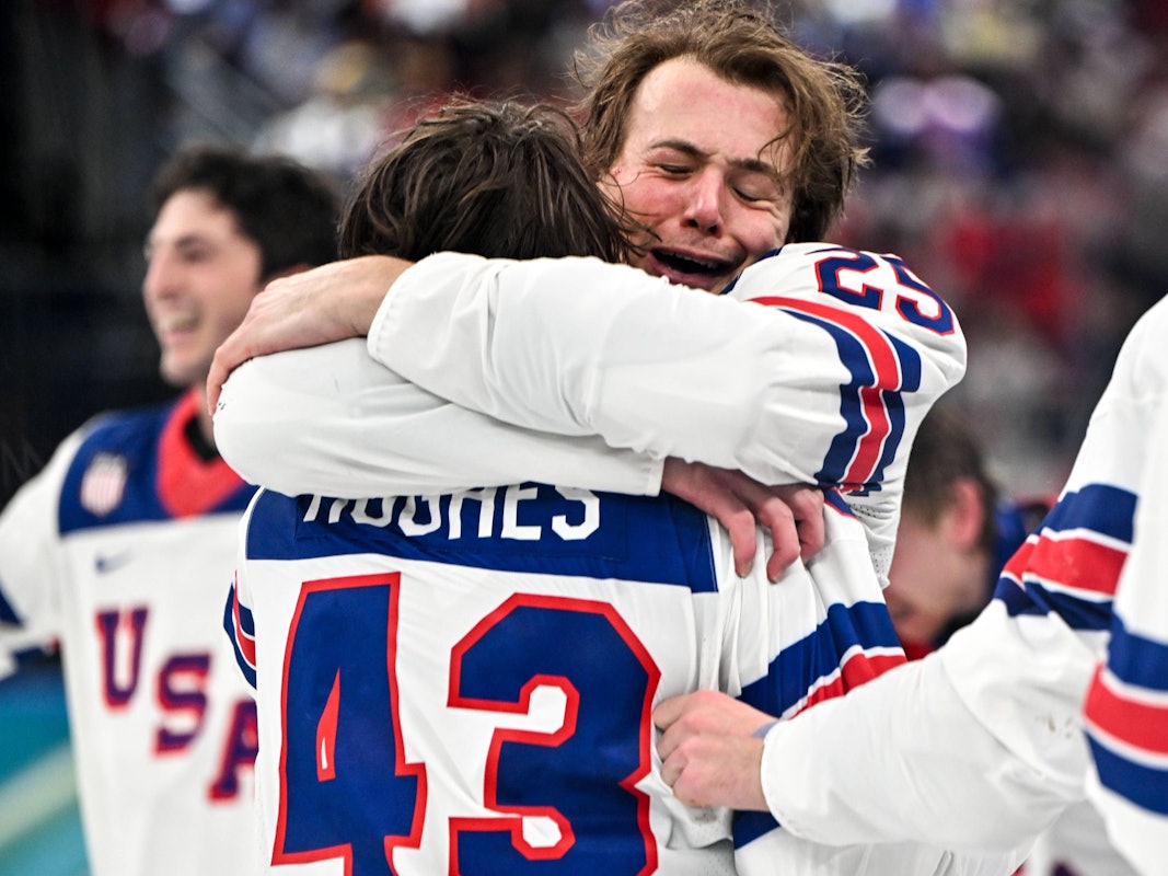 Charlie McAvoy umarmt Quinn Hughes nach dem Gewinn der Goldmedaille bei Olympia.