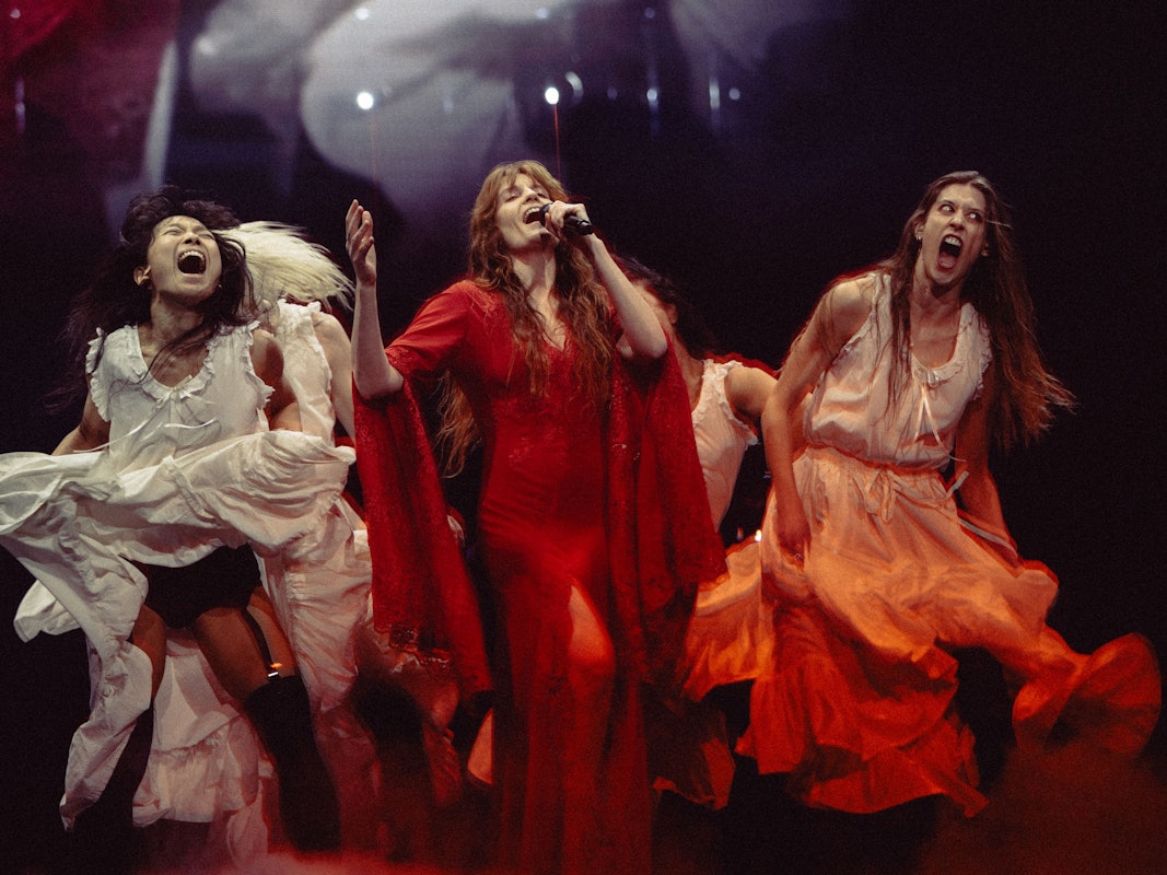 Sängerin Florence Welch auf der Bühne mit ihren Tänzerinnen.