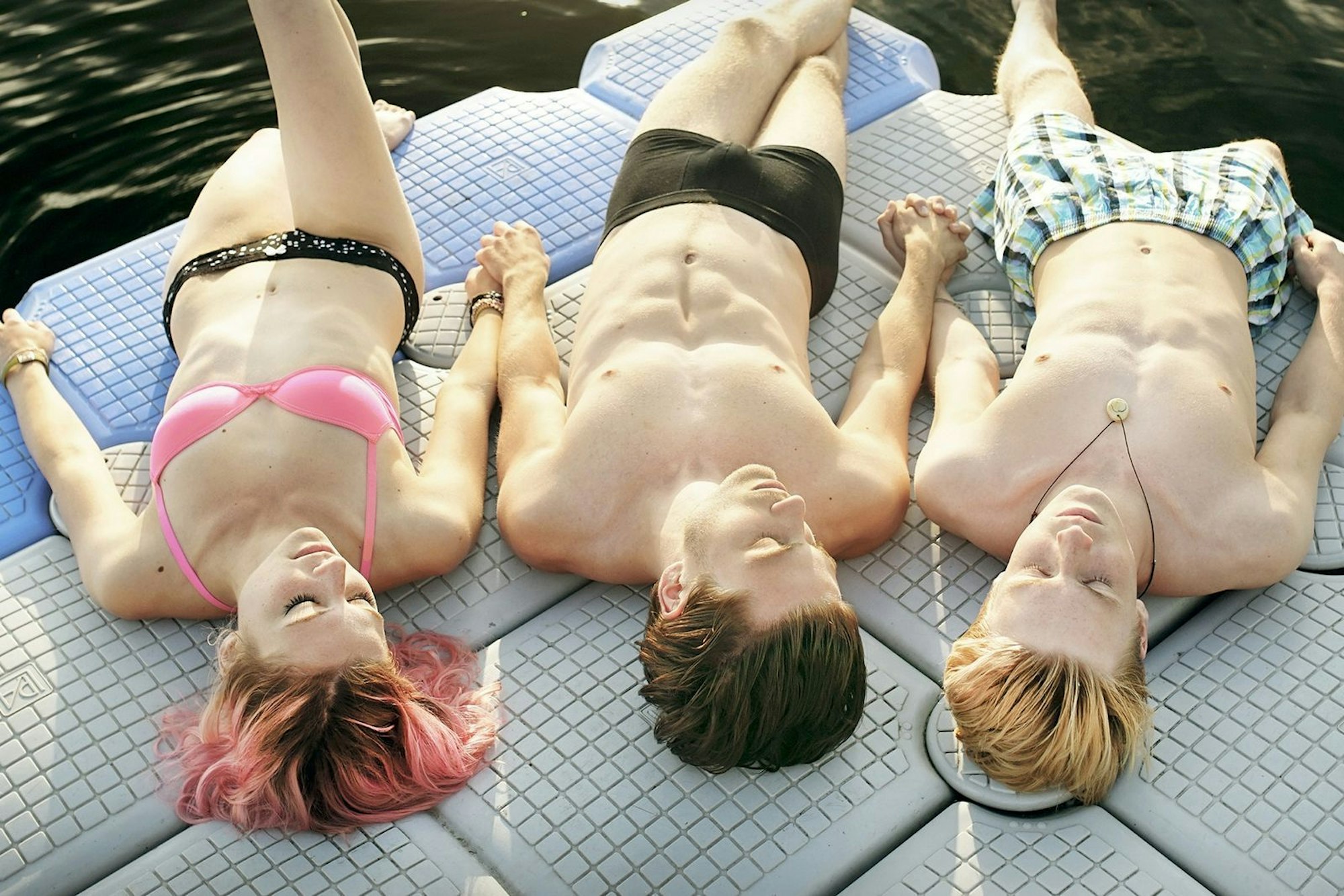 Gemeinsam mit seiner besten Freundin Kat (Svenja Jung) und seinem neuen Freund Nicholas (Jannik Schümann, Mitte) genießt Phil (Louis Hofmann) die Zeit am See. Die drei verbinden Leidenschaft und Leichtsinn. (Bild: ZDF/ORF/Prisma Film/Paul Ploberger)