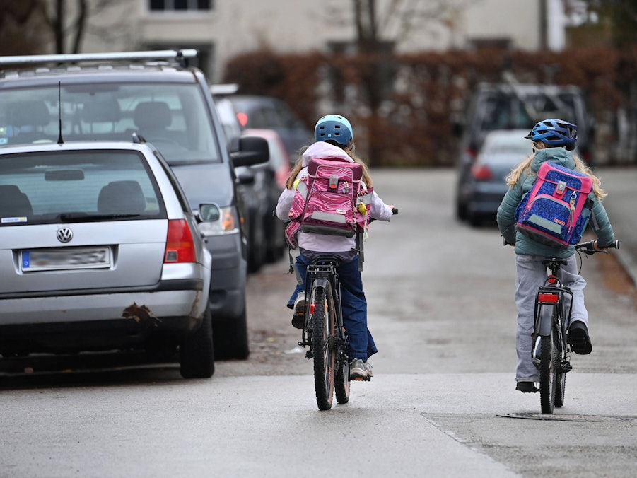 Zwei Schüler auf Fahrrädern mit Schulranzen