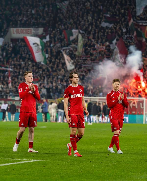Isak Johannesson, Jakub Kaminski und Florian Kainz gehen nach Spielende in Augsburg mit langen Gesichtern in die Kurve zu den FC-Fans.