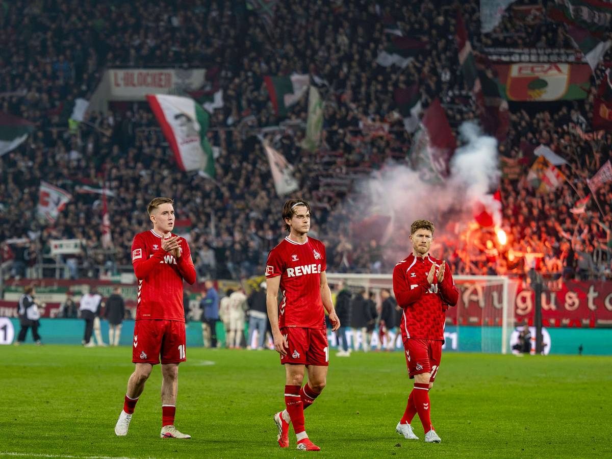 Isak Johannesson, Jakub Kaminski und Florian Kainz gehen nach Spielende in Augsburg mit langen Gesichtern in die Kurve zu den FC-Fans.