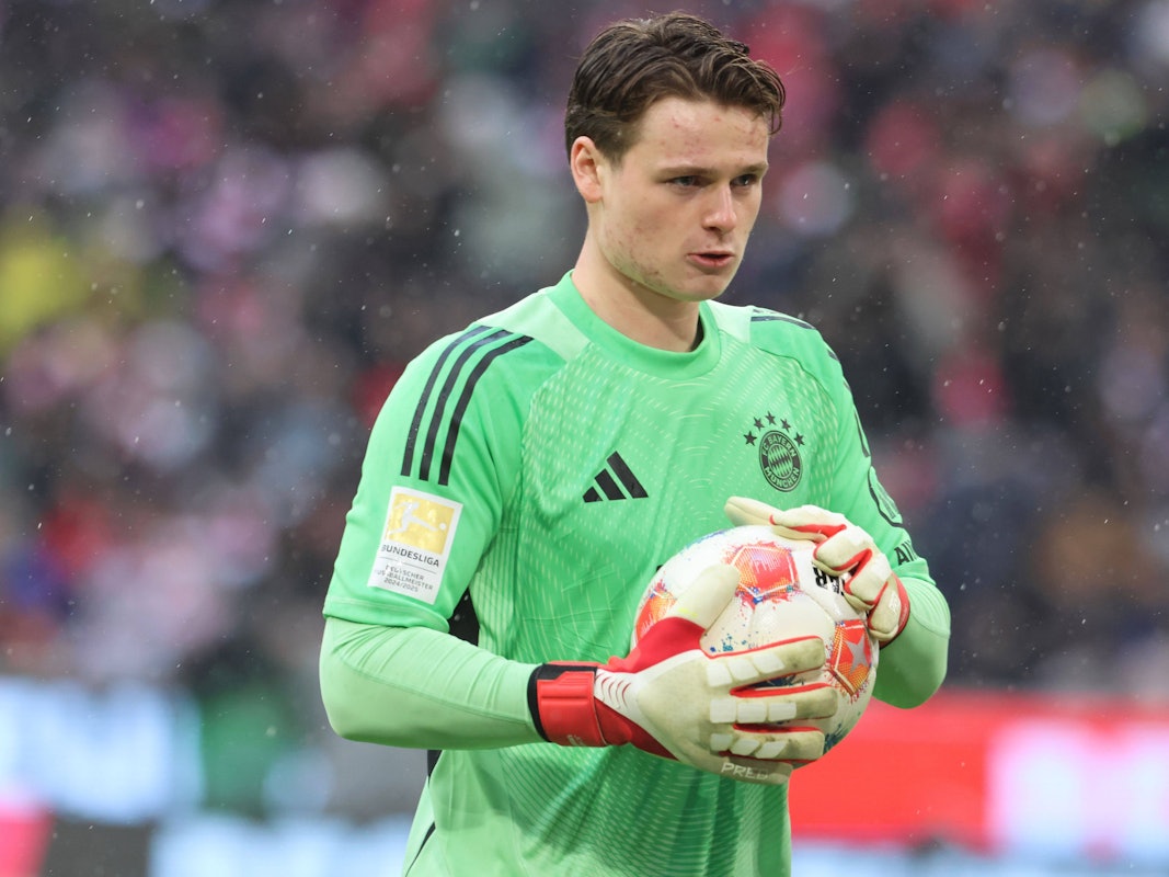 Jonas Urbig hält beim Spiel den Ball in der Hand.